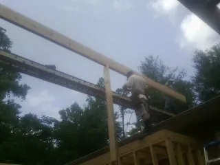 Carpenter setting a ridge beam over a new addition frame — Ice Dam Removal by Roofing Brothers in Beatrice