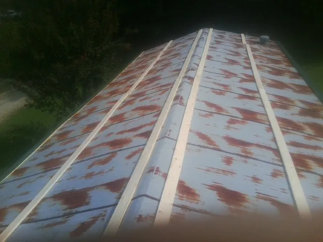 Rusted metal roof panels with new wood purlins before replacement — Storm Damage Roof Repair in Beatrice by Roofing Brothers