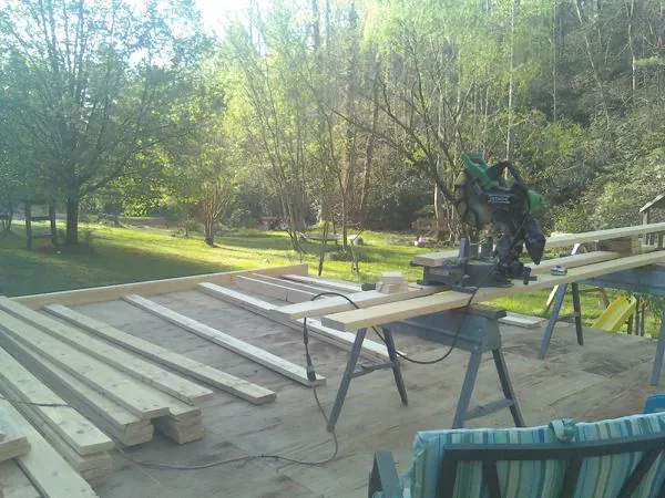 Miter saw and framing lumber on a deck under construction in Beatrice